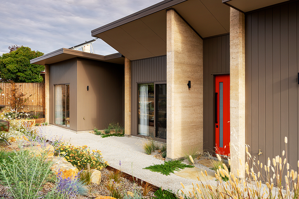 Side on North view of the home with rammed earth and Weathertex cladding