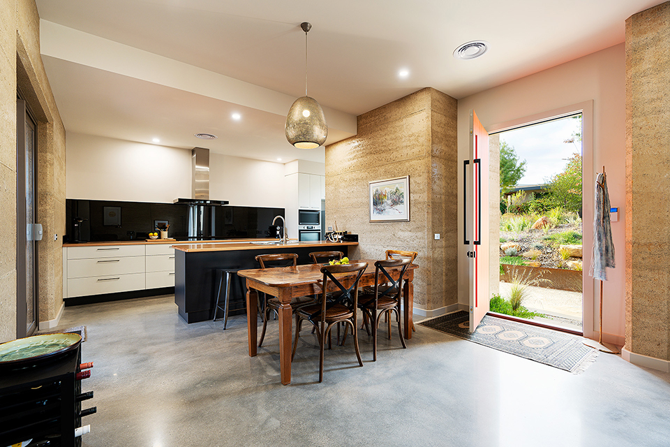 View of open plan kitchen/dining and front door open to beautiful garden