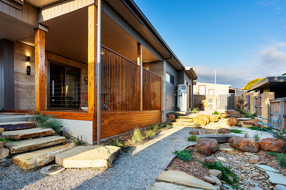 South garden of home with landscaping rocks, large wooden posts and screening